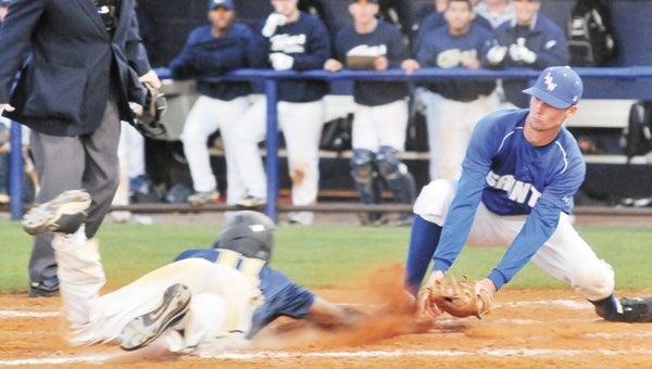 Saints pitcher Ben Pettus tries to tag a runner out at home during an earlier contest this season. LBWCC split with Huntingdon College Thursday. |                      File photo