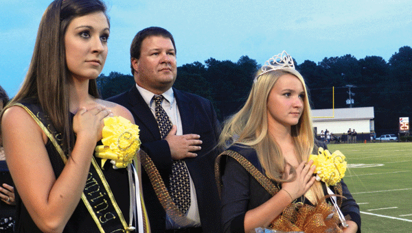 Last year’s SHS queen Taylor Wood, left, with 2013 queen Jordan Wood, right, are shown during the national anthem. Jordan was escorged by her uncle, Doyle Lambert, because her father is in Afghanistan. 