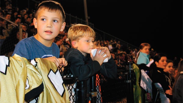 Young Straughn Tiger football fans Zade Newton, left, and Tucker Ward, watch the pep rally Thursday night, patiently awaiting tonight’s home playoff game with Bayside.    