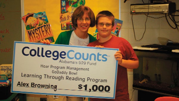 Browning and teacher Barbara Peek show off his check for a $1,000 college savings bond.
