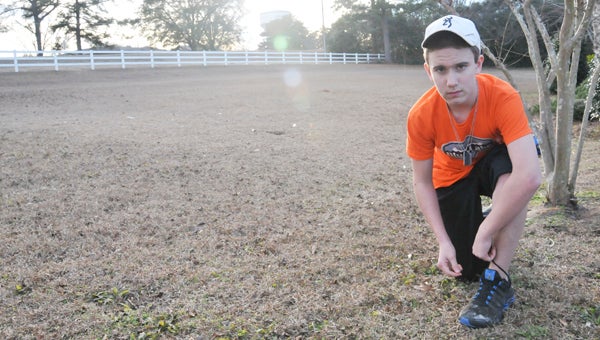 Taylor Copeland laces up his shoes to go on a run Tuesday afternoon. | Andrew Garner/Star-News