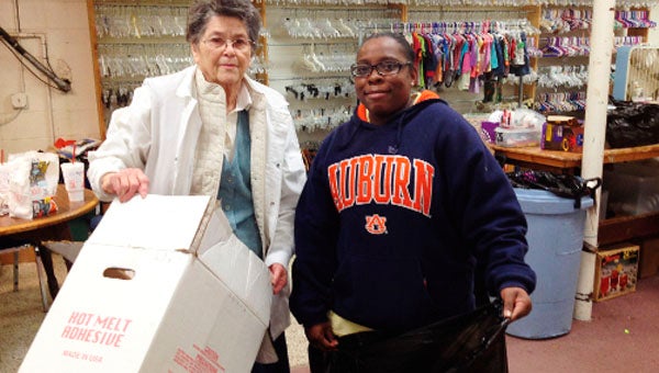 Glenda Mosley and Felicia Taylor bag clothes for disposal Thursday at the Christian Service Center.   
