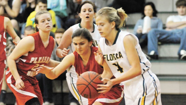 Pleasant Home's Anna Bulger (center) tries for the ball as Florala's Riley Edwards goes in the paint. | Andrew Garner/Star-News
