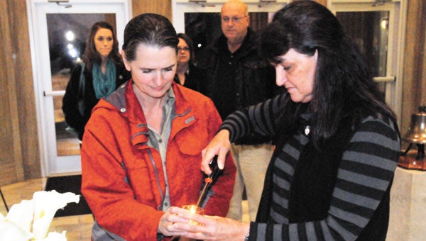 Above: Marilyn Williams (right) and Christy Watts light a candle in remembrance of a loved one who passed recently.