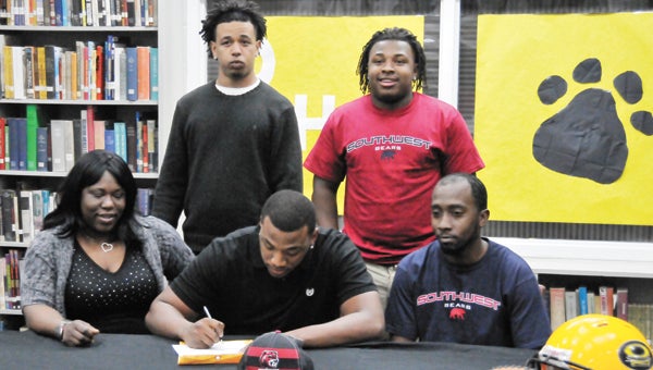 Opp’s Derek Savage signs his commitment letter to Southwest Mississippi Community College Thursday afternoon. He is shown here with his mother, Shemika Savage; brothers, Tay Smith, Dyrian Savage and Nathaniel Smith.        | Andrew Garner/Star-News