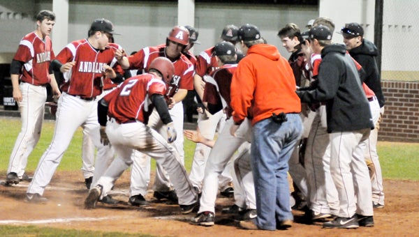 Andalusia baseball players celebrate mob teammate Grayson Campbell (2) at home plate Thursday night. Campbell hit a three-run home run to give the Bulldogs a 3-1 lead in the top of the sixth inning. | Andrew Garner/Star-News