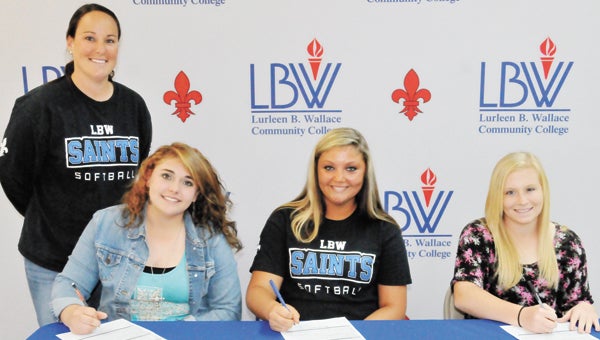 LBWCC softball coach Candace Tucker (far left) stands with Lady Saints signees Jessica Carden, Chanin Hancock and Tara Trant as they sign their letters of intent Wednesday afternoon. | Andrew Garner/Star-News