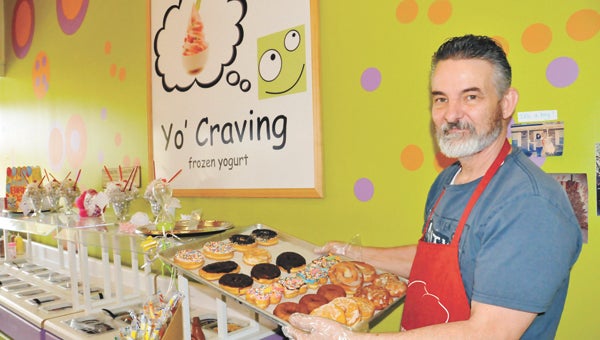 Donny Harris, owner of Yo’ Craving, shows of his dispaly of doughnuts Friday afternoon.  