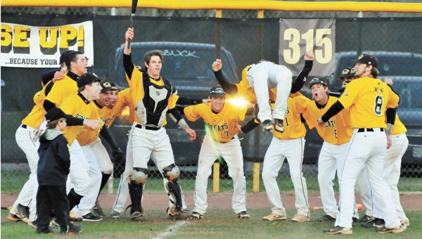 Opp’s Zane Hollinghead (center and in air) goes through his normal pre-game acrobatic routine before the Bobcats played T.R. Miller Tuesday night. OHS is No. 8 in this week’s baseball poll. | Andrew Garner/Star-News