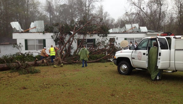 Dozier Volunteer firefighters work to clear away debris and remove a tree from this mobile home on Leon Tower Road near Dozier Sunday morning. (Photo courtesy of Robert White)