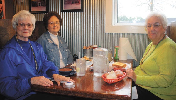 Patrons, from left, Grace Foreman, Bobbie Lambert and Joyce Lambert use the new Kallpod call button to signal their server Tuesday at David’s Catfish House.