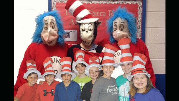 This image combines two photographs. In the background are characters from Straughn Elementary's Seuss parade- Thing 1, Thing 2 and Cat in the Hat. In the foreground are students at Andalusia Elementary, where there were cat in the hat hats galore!