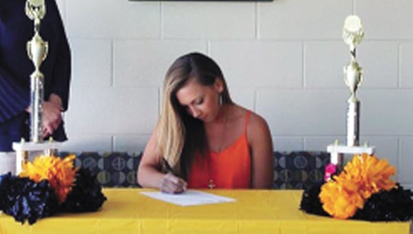 Finley signs her scholarship.
