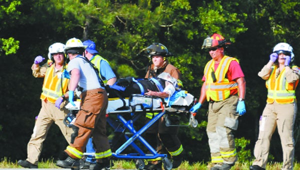 Opportunity EMS EMTs, Opp Fire Department Firefighters and the pilots wheel the woman who was involved in a one-vehicle accident to the helicopter to be air-lifted Tuesday afternoon. 