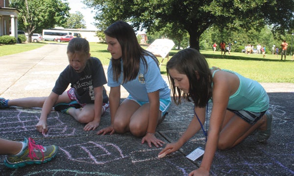 Sidewalk chalk drawings in the shade were a great way to beat the heat during VBS at First Baptist Church in Andalusia. Shown are, from left, Sophia Jones, Savannah Gomillion and Anna Duffy.