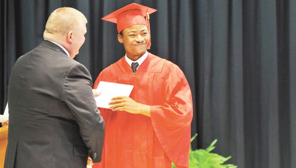 Pleasant Home senior LaDarius Woods receives his diploma from PHS Principal Craig Nichols Thursday night. | Andrew Garner/Star-News