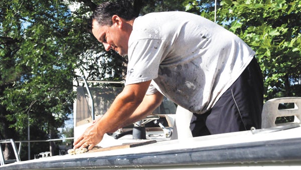 Andalusia resident Ken Clarke washes his boat at his Second Street home late Wednesday afternoon. Clarke said he waited until the heat dissipated to clean his boat. | Andrew Garner/Star-News 
