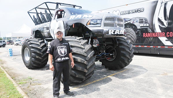 Driver Seth Jeffers stands in front of the Raminator, an 11-foot tall monster truck, at Massey Automotive Friday morning. The Raminator and Hall Brothers Racing will offer free rides today from 10 a.m. until 5 p.m. | Andrew Garner/Star-News