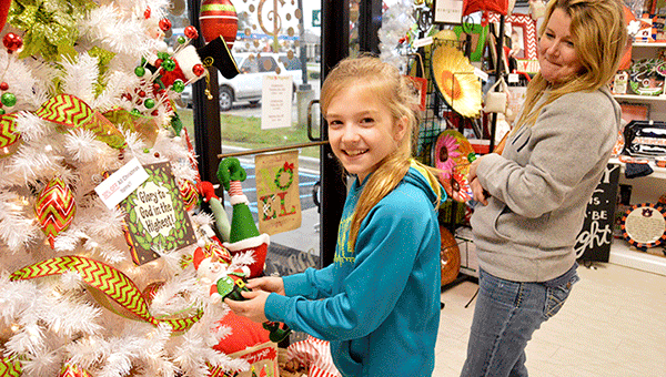 Caylee Douglas picks out an elf Christmas tree ornament with her mother, Delores, at Pink Peppers. 
