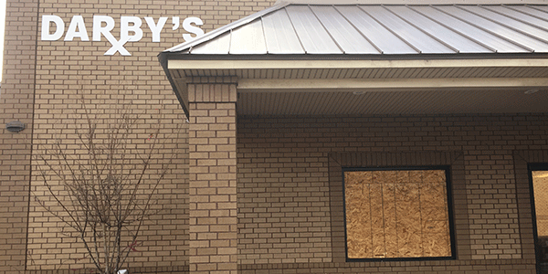 The window of Darby's Pharmacy remained boarded up Saturday afternoon after the pharmacy was one of two burglarized early Saturday.