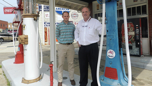 Charles Smith, right, stands with his son at the filling station in this 2013 file photo.