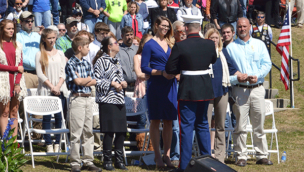 A member of the Marine Honor Guard presents a flag to Elizabeth Turner.