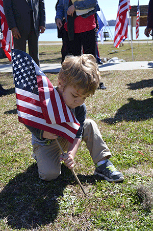 Jamieson Jackson, 4, plants a flag in the ground near the memorial for Turner. 