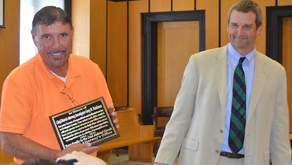 Gary Hutcheson of the District Attorney’s office is presented a plaque by current DA Walt Merrell. 