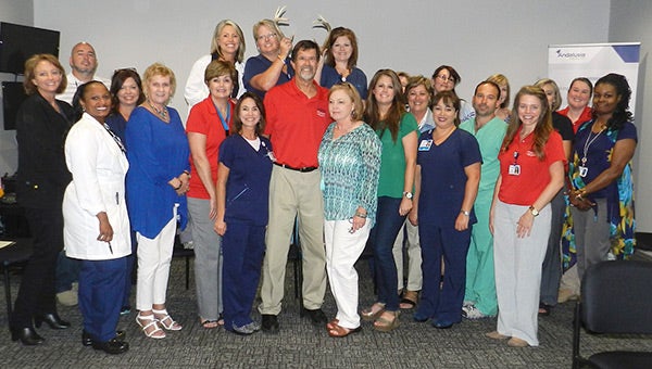 Michael Holloway insisted that family members and co-workers pose with him at his retirement party at Andalusia Health Friday afternoon.
