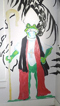 One of the many frogs painted on the walls of the home.