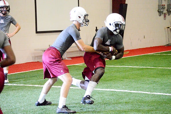 Junior quarterback Ethan Wilson hands off to senior running back Jamal Hourel during Andalusia’s first full practice of the 2016 football season.