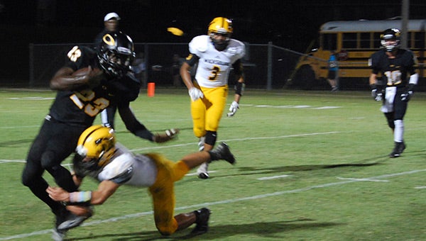 Opp’s Hennis Washington tries to escape a Wickburg tackler Friday night. Washington had 18 rushes for 97 yards and two touchdowns.  Photo by Tripp Norris